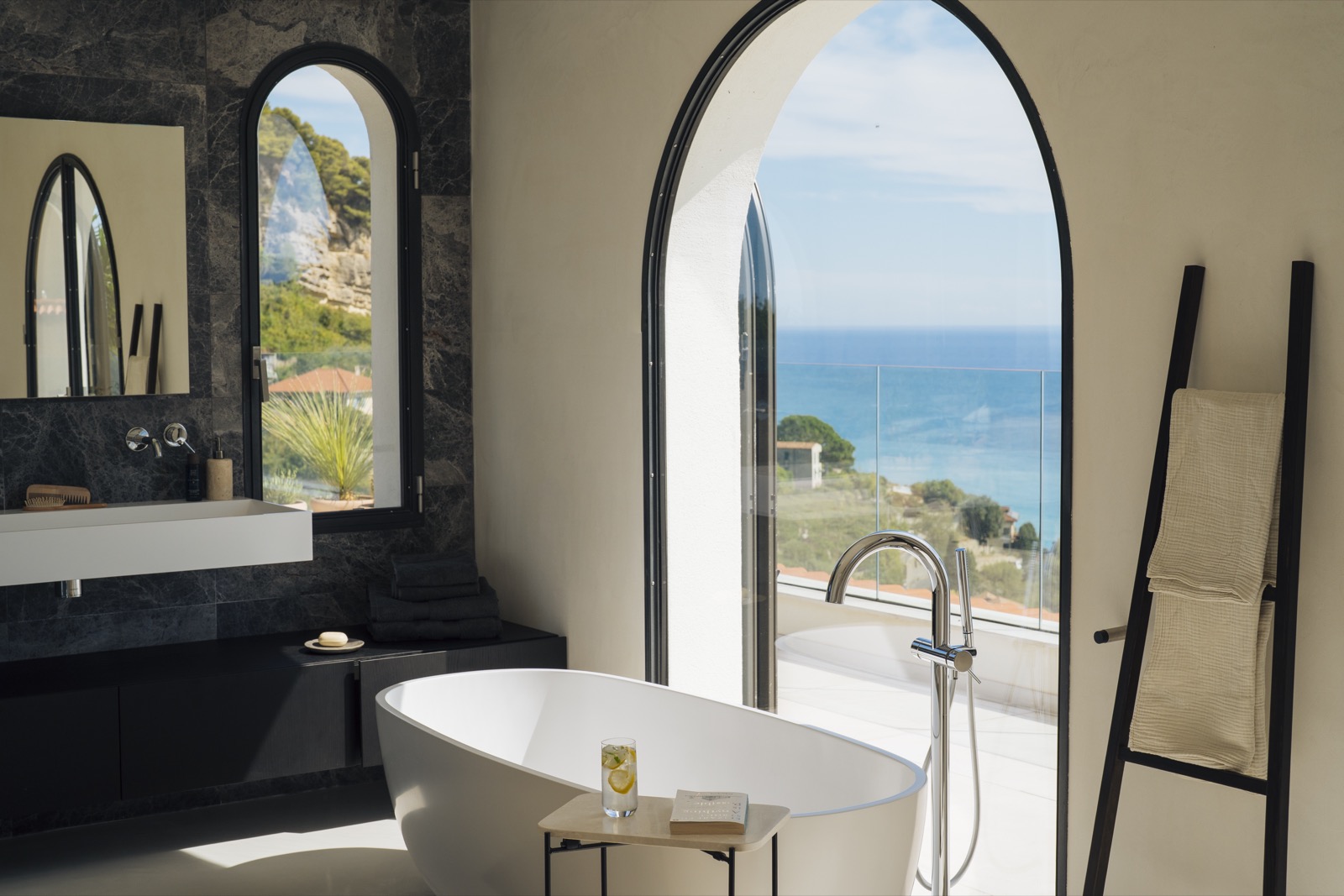 Dark marble bathroom with freestanding tub
